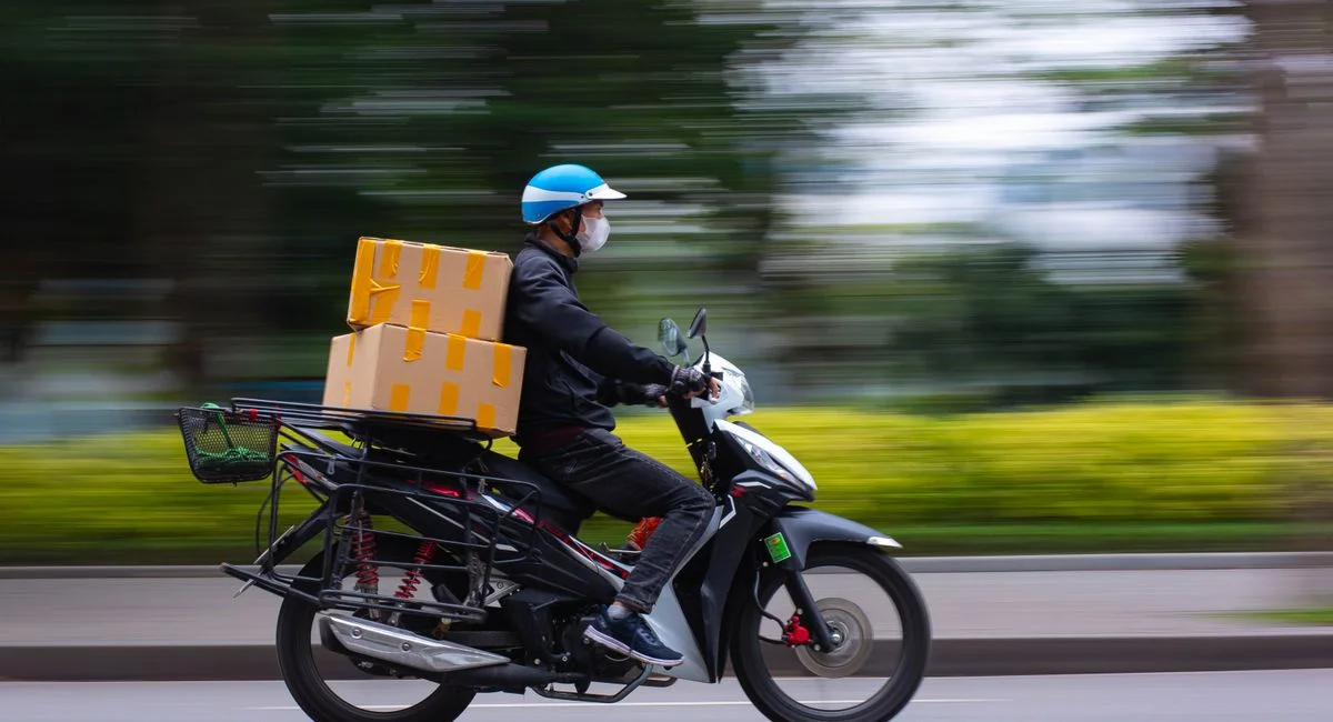 Fast-paced delivery service on a scooter in urban setting, capturing motion and speed.