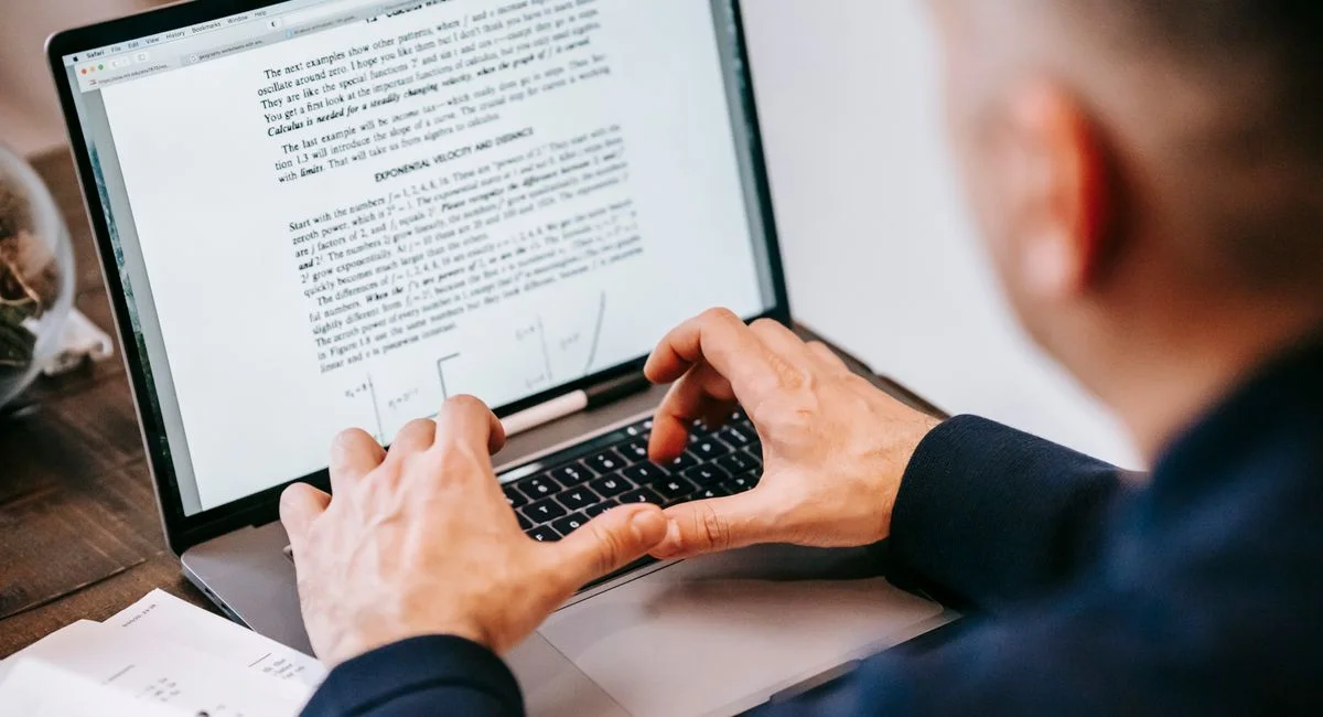 Man typing on laptop at home office, focused on work, illustrating remote work lifestyle.
