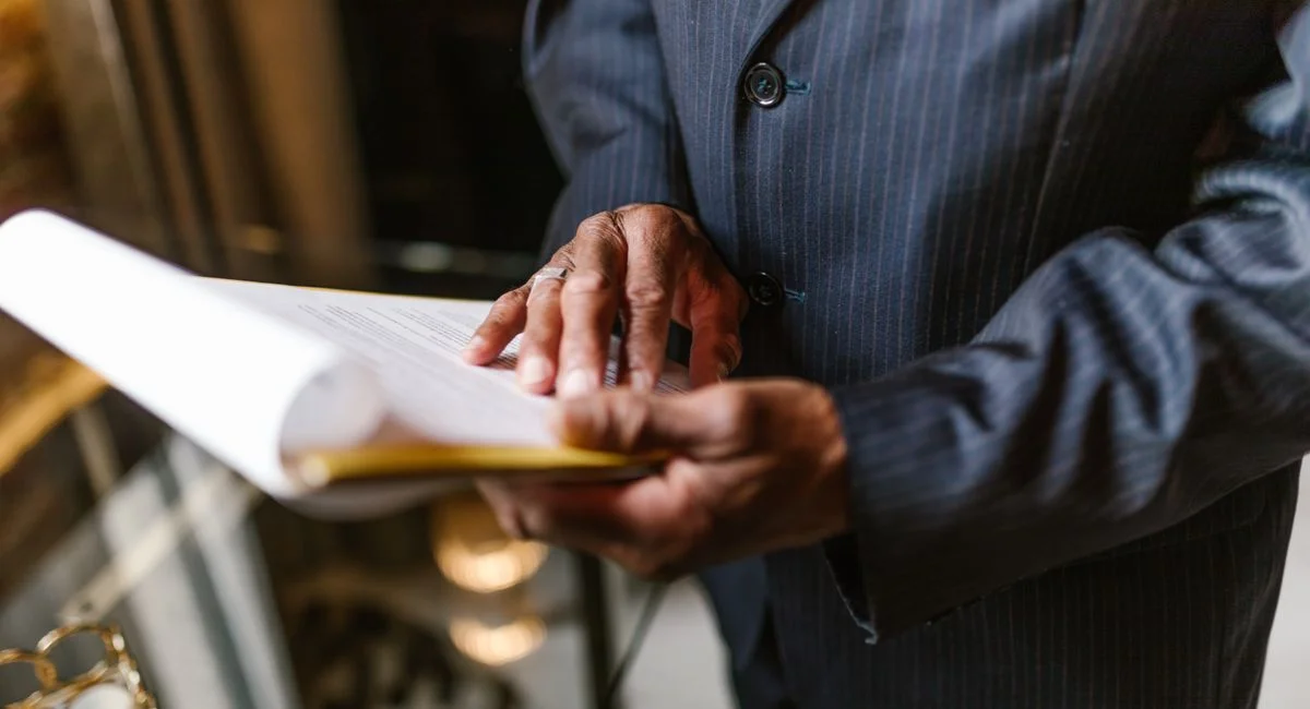 Close-up of a businessman in a suit attentively reviewing a document indoors.