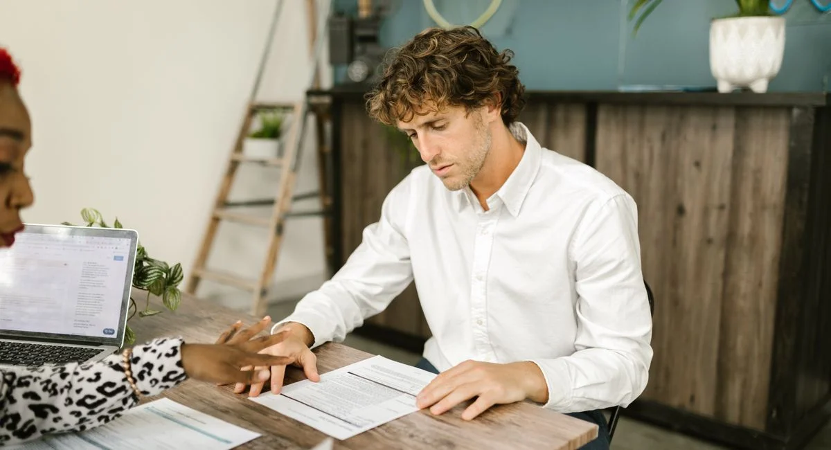 Two professionals discussing financial documents in an office setting.