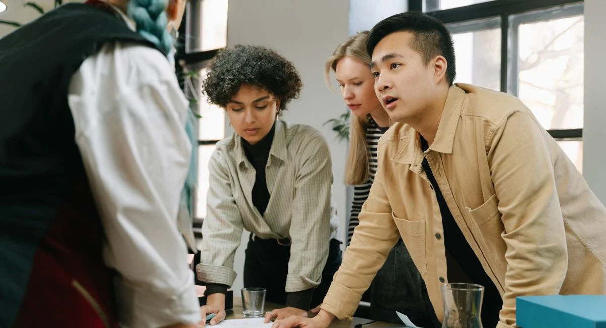A diverse group of coworkers engaged in a collaborative meeting in a modern office setting.