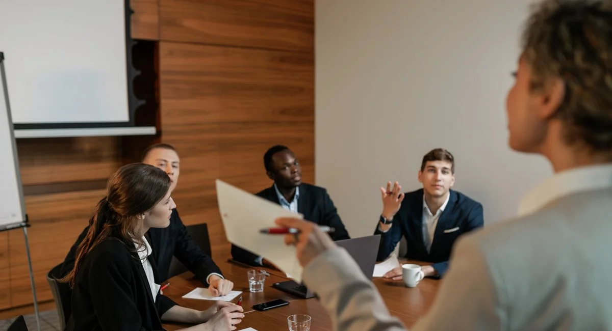 Professional business team engaged in a discussion in a modern conference room setting.