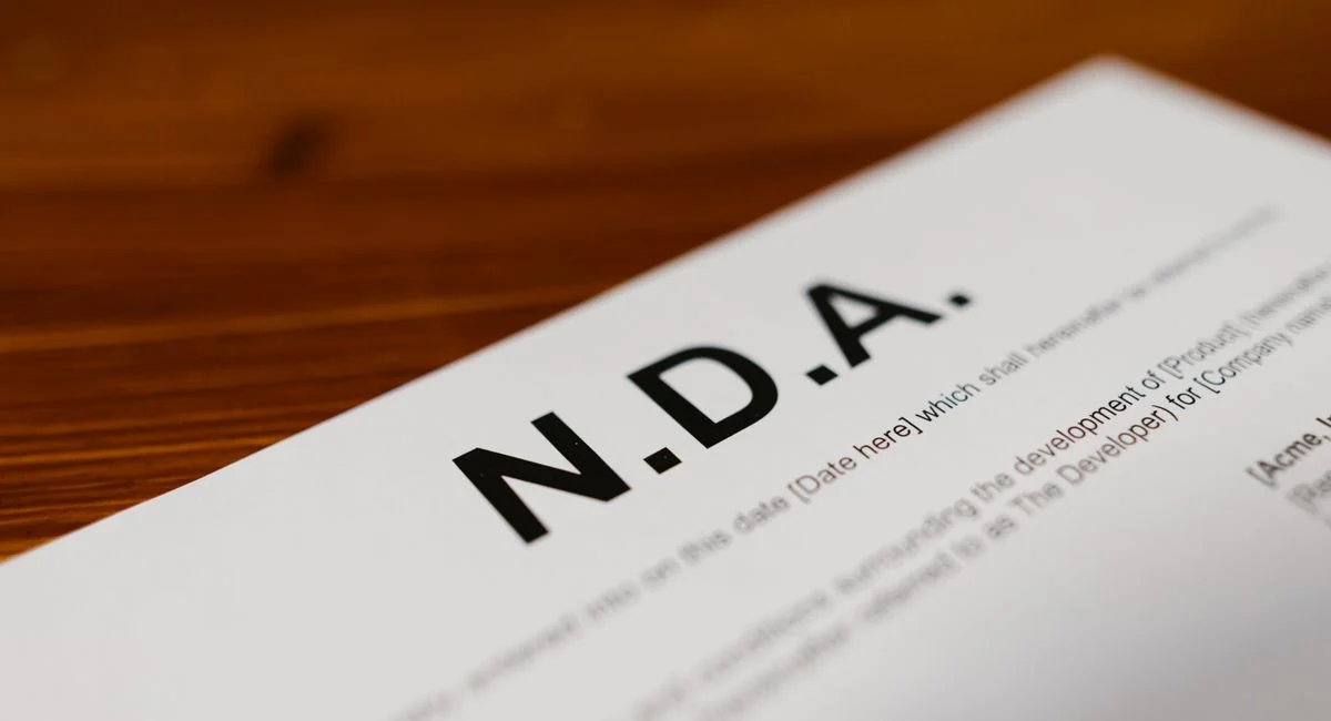 Focused close-up of an NDA document on a wooden desk, highlighting contract details.
