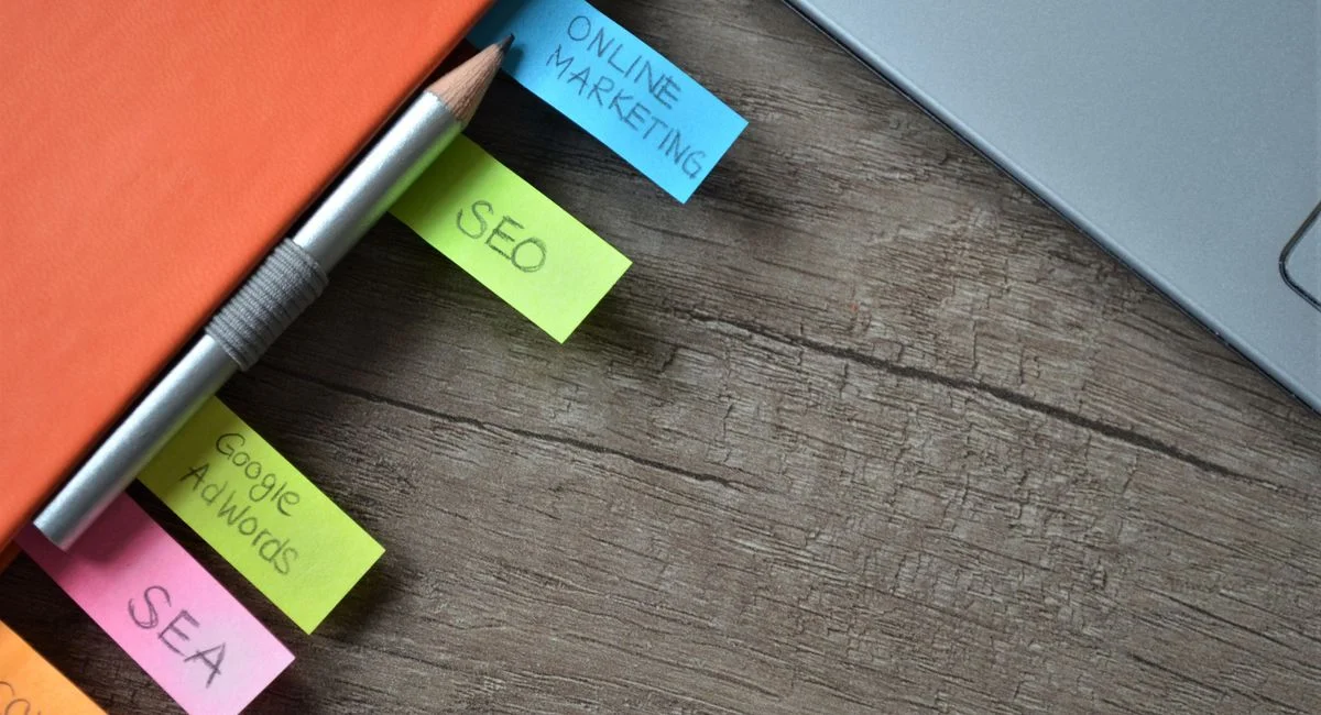 Close-up of SEO strategy planner with colorful sticky notes and a pencil on a notebook.