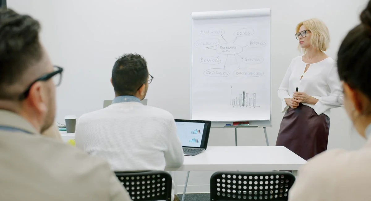 Business meeting with focus on strategic models presented on a flipchart.