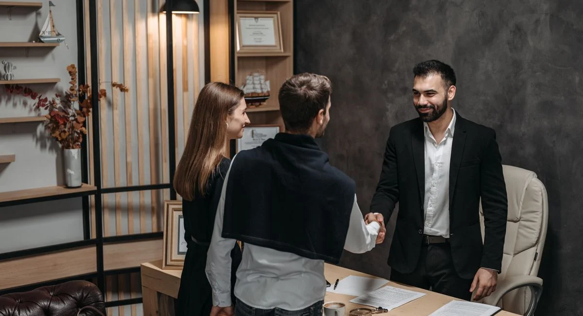 Professional business meeting in modern office setting with a handshake.